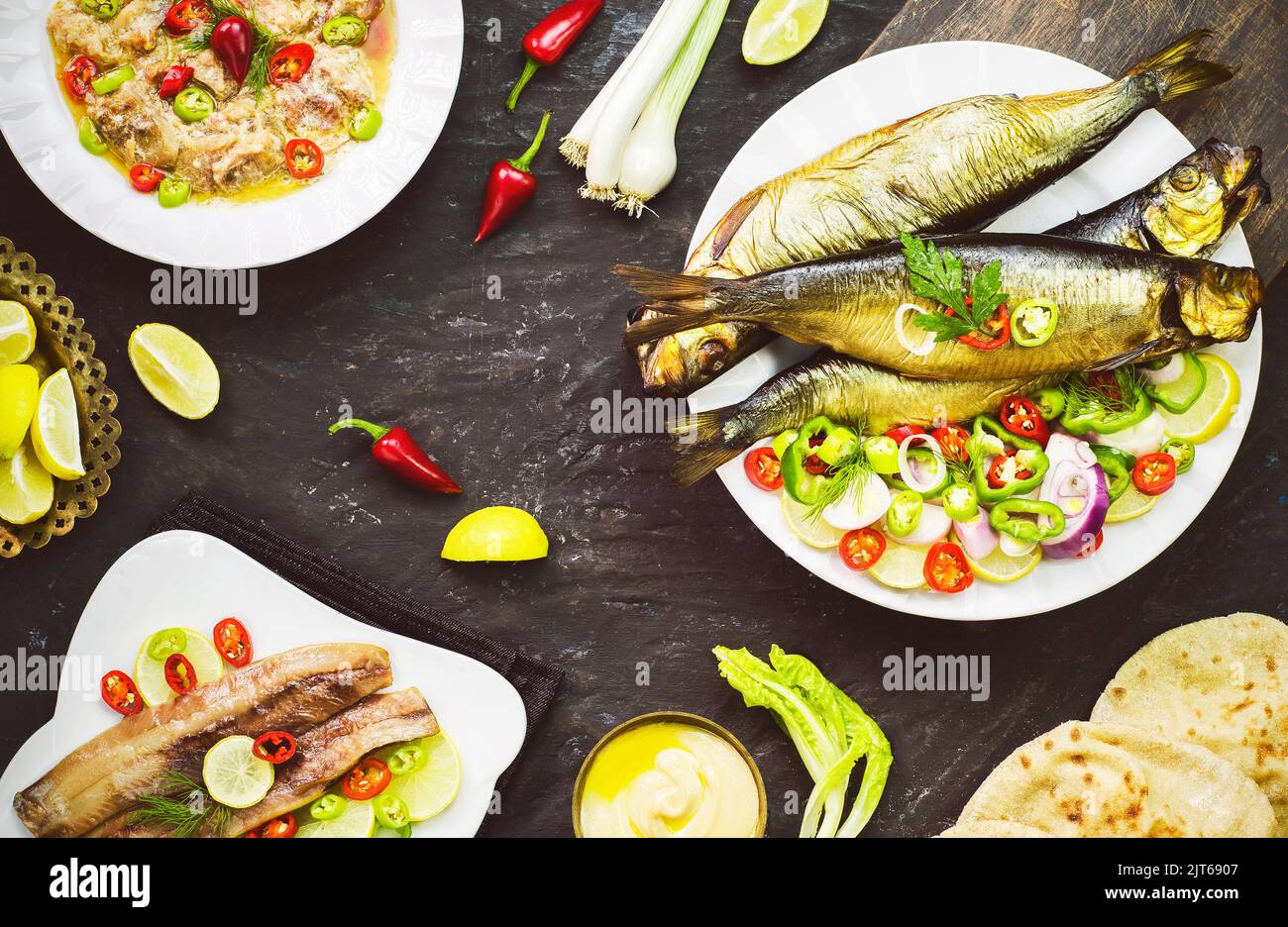 Cuisine méditerranéenne, poisson fumé au hareng servi avec de l'oignon vert, du citron, du piment, de la laitue, des épices, pain pita et sauce tahini. Banque D'Images