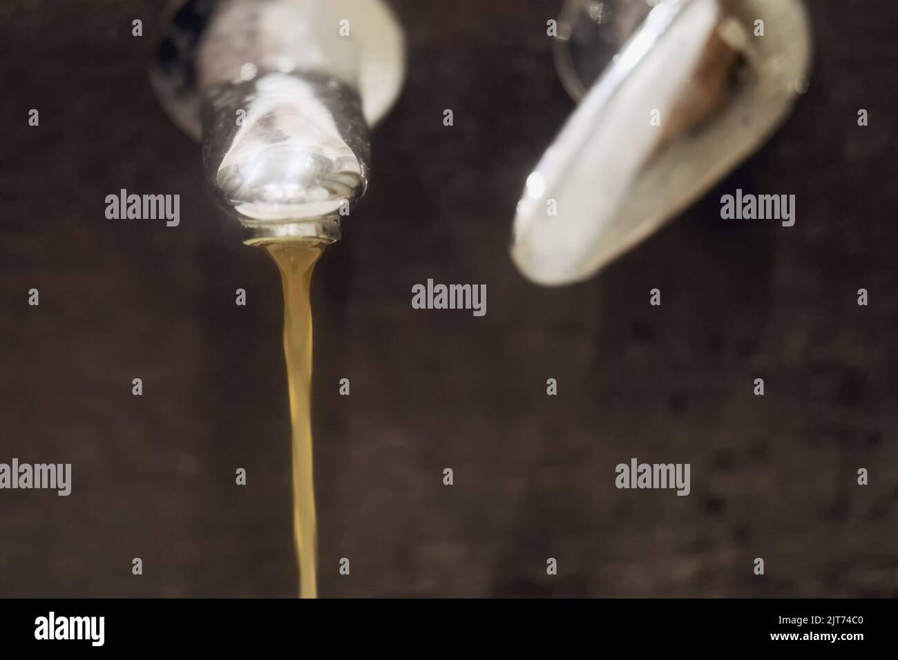 De l'eau sale rouillée coule dans un évier d'un robinet Banque D'Images