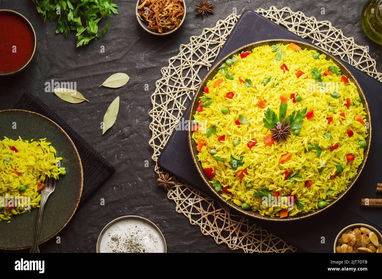 Cuisine arabe; riz basmati arabe traditionnel avec légumes. Servi avec une sauce tomate et yaourt, des oignons frits croustillants et des noix grillées dorées. Banque D'Images