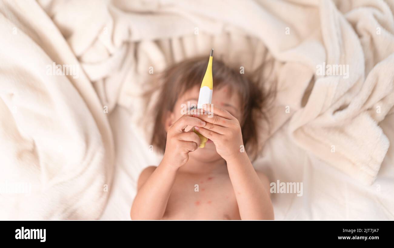 Enfant couché dans le lit avec Thermomie Banque D'Images