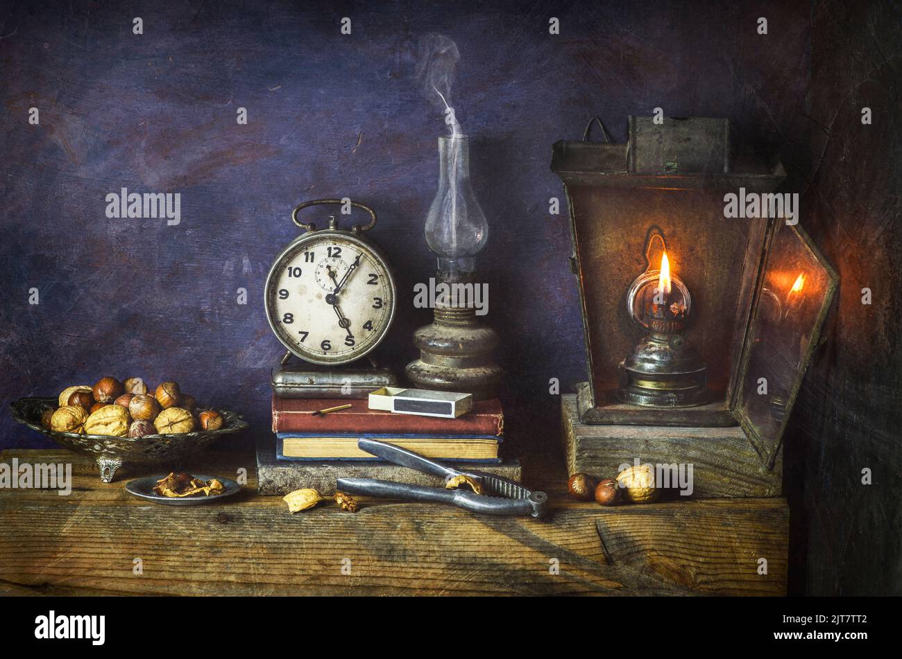 Un classique encore plus vivant avec des livres vintage placés avec une vieille horloge, une lampe d'époque éclairée et un casse-noisette sur fond de bois rustique. Banque D'Images