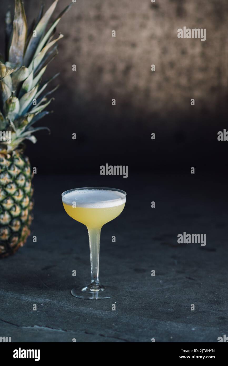 cocktail jaune tropical en verre coupé à tige creuse avec ananas Banque D'Images
