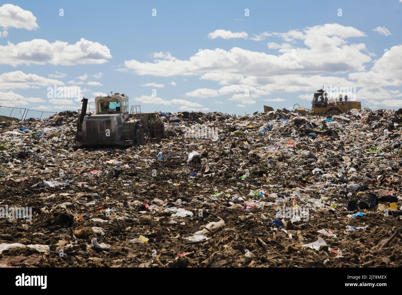 Des machines lourdes dispersent et compacent les débris et les déchets rejetés sur le site de gestion des déchets. Banque D'Images