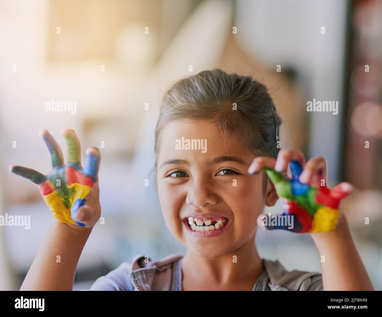 Vous devez être désordonné pour faire preuve de créativité. Portrait d'une petite fille avec ses mains couvertes de peinture. Banque D'Images