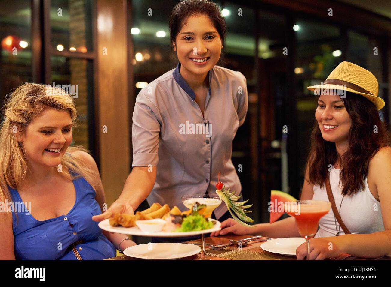 Le dîner est servi. Portrait d'une serveuse servant des clients dans un restaurant. Banque D'Images Le dîner est servi. Portrait d'une serveuse servant des clients dans un restaurant. Banque D'Images
