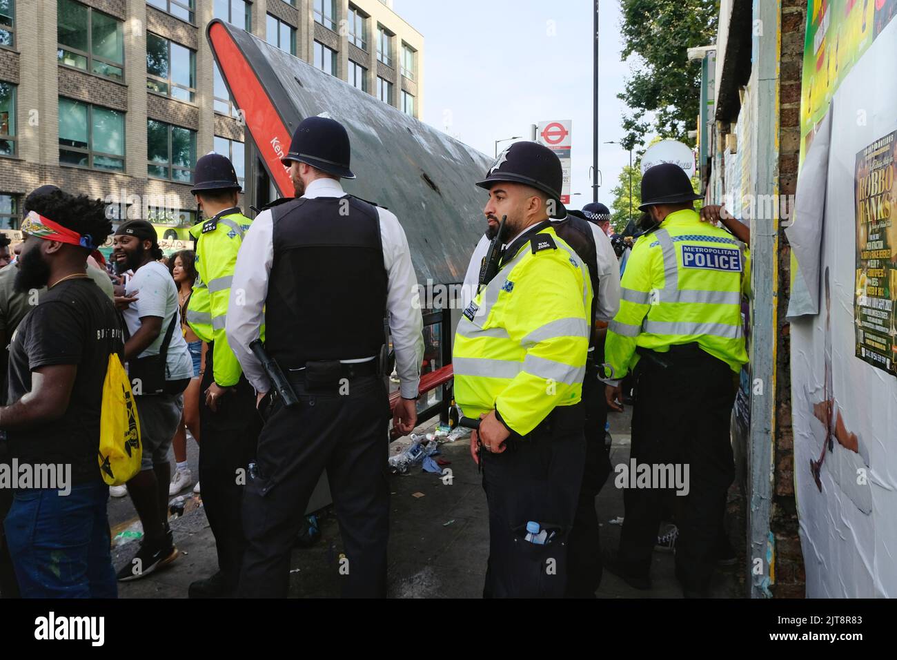 Londres, Royaume-Uni, 28th août 2022. Un abri de bus s'effondre après le poids d'une demi-douzaine de fêtards l'ont fait céder la place. Le Carnaval de Notting Hill revient à Londres après un hiatus de trois ans causé par la pandémie de Covid avec la Journée des enfants - ou la Journée de la famille. On estime que deux millions de personnes devraient visiter la région pendant le week-end des fêtes de banque. En plus des défilés animés qui ont lieu, des scènes, des systèmes sonores, des stands de nourriture et de boissons des Caraïbes sont parsemés le long du parcours. Crédit : onzième heure Photographie/Alamy Live News Banque D'Images