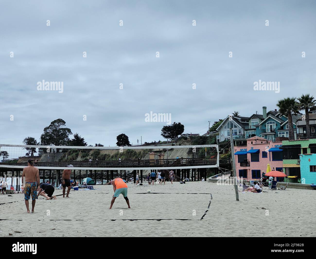 Une vue sur la plage de Capitola avec des maisons colorées et des personnes jouant au basket-ball, Californie Banque D'Images