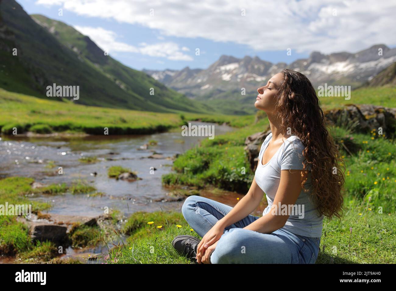 Vue latérale portrait d'une femme décontractée qui respire dans une vallée de montagne Banque D'Images