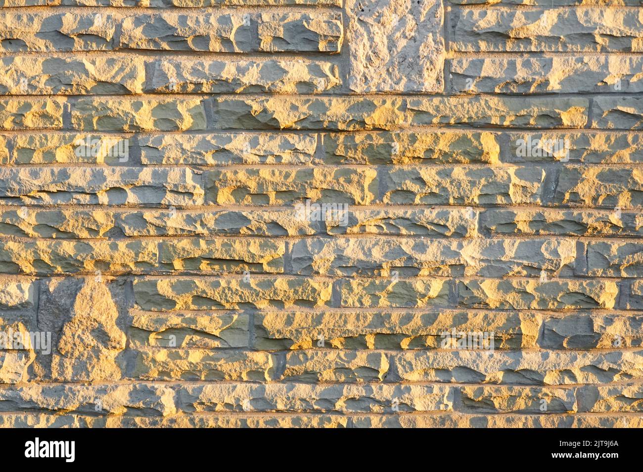 Soleil sur des blocs de pierre naturelle de York coupés et vêtus de dalles Londres redondantes réutilisées dans la peau externe de la maison mur cavité Essex Angleterre Royaume-Uni Banque D'Images