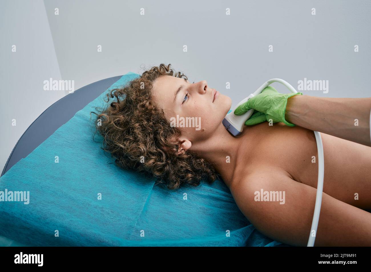 Le patient garçon reçoit un diagnostic de la glande thyroïde. Examen système endocrinien de l'enfant à la clinique médicale avec l'échographe Banque D'Images