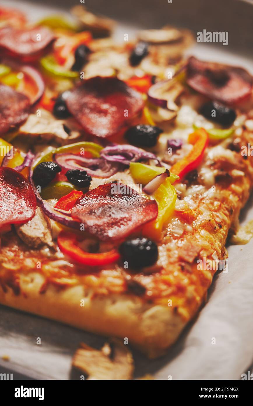 Un morceau de pizza carrée avec des tomates au basilic et des champignons sur un plateau en fer, servi avec des ingrédients frais. Vue de la mise à plat. Banque D'Images
