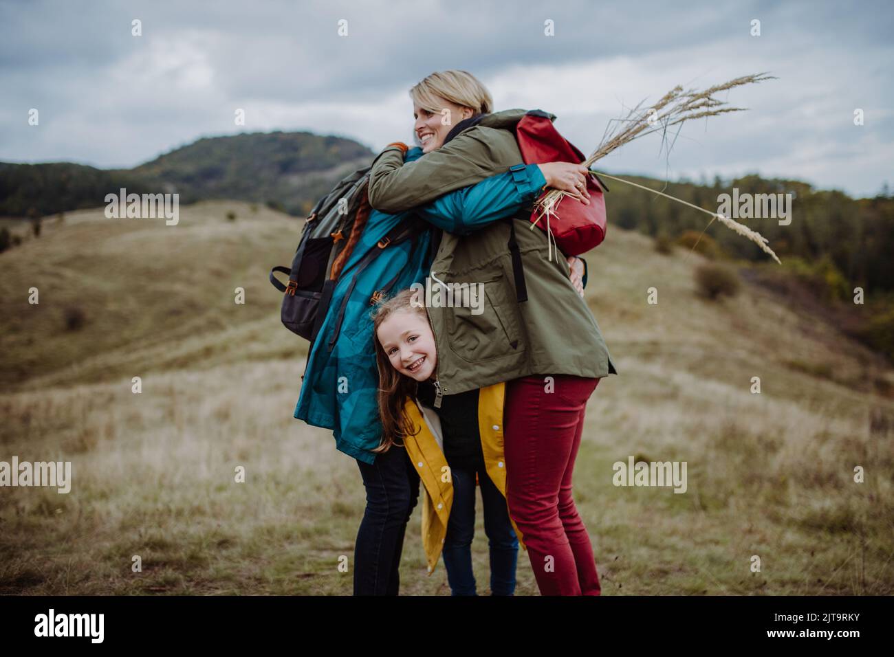 Petite fille avec mère et grand-mère debout et embrassant au sommet de la montagne. Banque D'Images