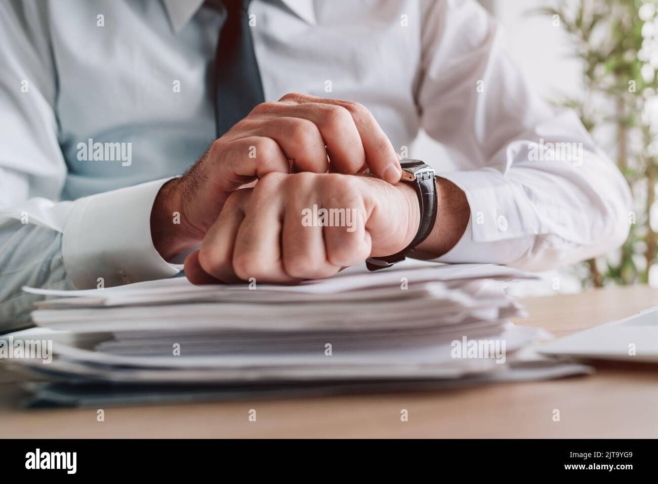 Date limite d'affaires, homme d'affaires regardant la montre et l'heure de vérification, gros plan des mains avec une attention sélective Banque D'Images