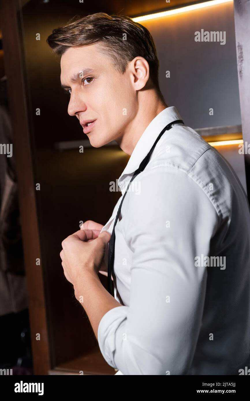 Élégante chemise homme à fesses dans une garde-robe le soir Banque D'Images