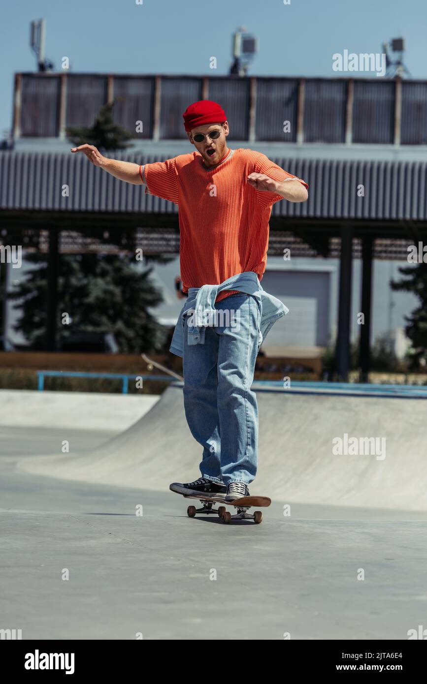 pleine longueur de l'homme excité dans une tenue tendance de skate sur la  rampe Photo Stock - Alamy