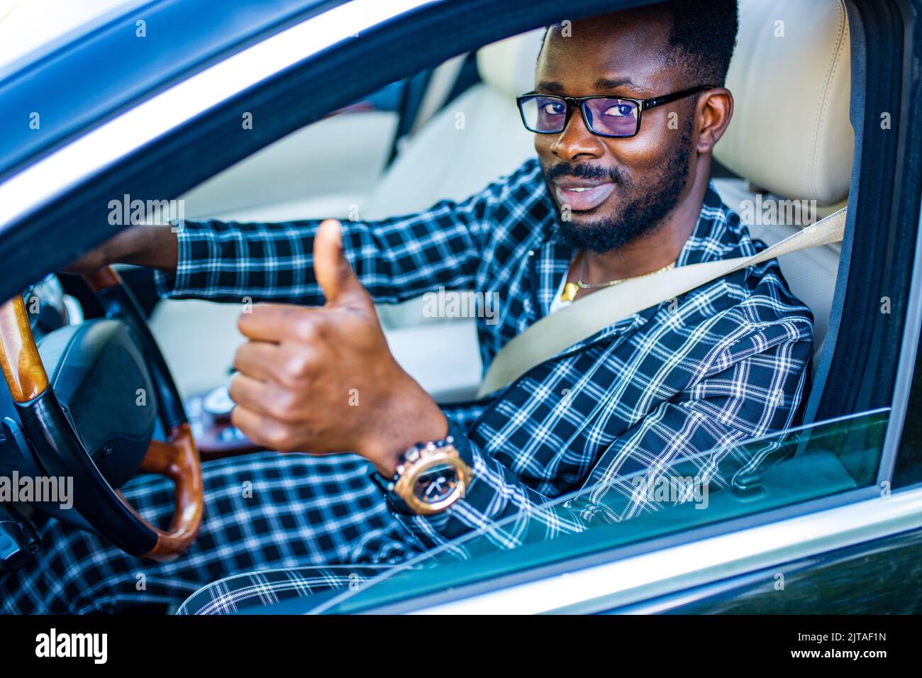 Beau barbu homme assis détendu dans sa voiture nouvellement achetée à l'extérieur. Banque D'Images Beau barbu homme assis détendu dans sa voiture nouvellement achetée à l'extérieur. Banque D'Images