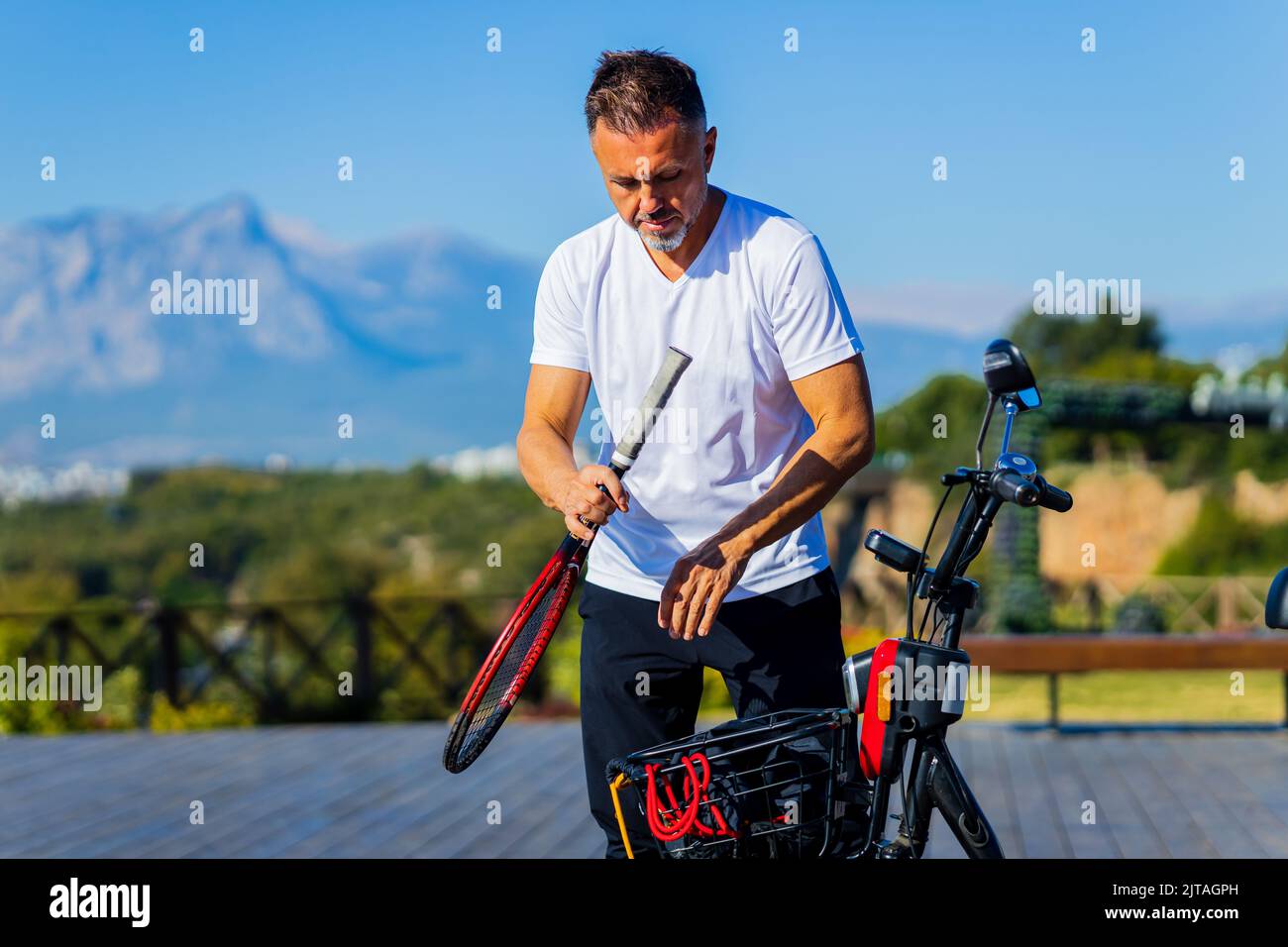 vieil homme bon loking à l'extérieur avec scooter écologique en vacances Banque D'Images