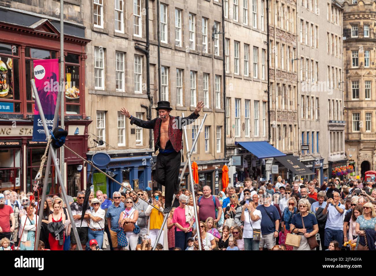 Un bus du Festival d'Édimbourg sur le Royal Mile effectuant des randonnées en corde raide Banque D'Images
