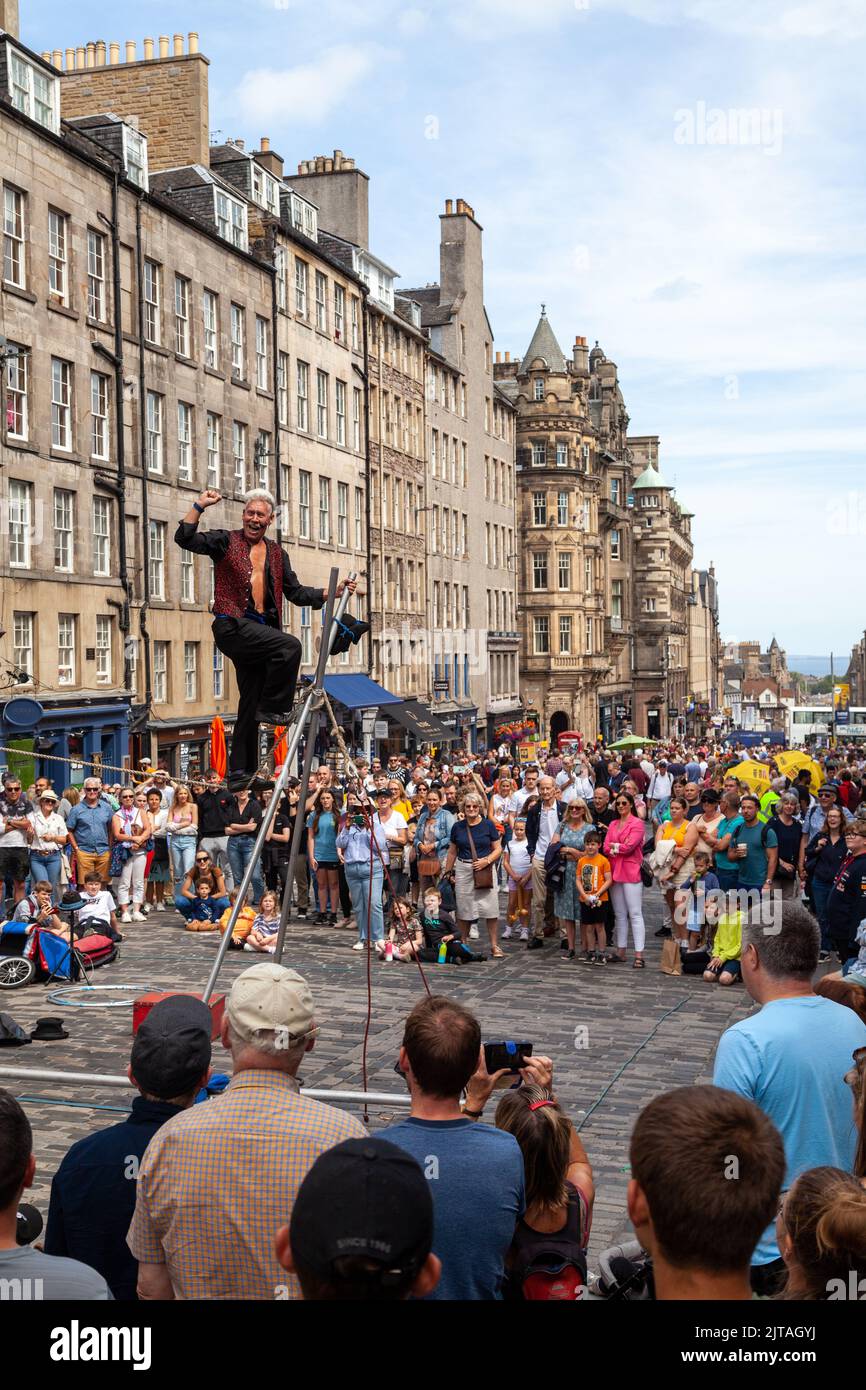 Un bus du Festival d'Édimbourg sur le Royal Mile effectuant des randonnées en corde raide Banque D'Images