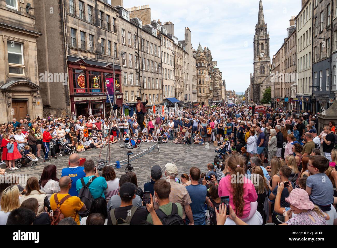 Un bus du Festival d'Édimbourg sur le Royal Mile effectuant des randonnées en corde raide Banque D'Images