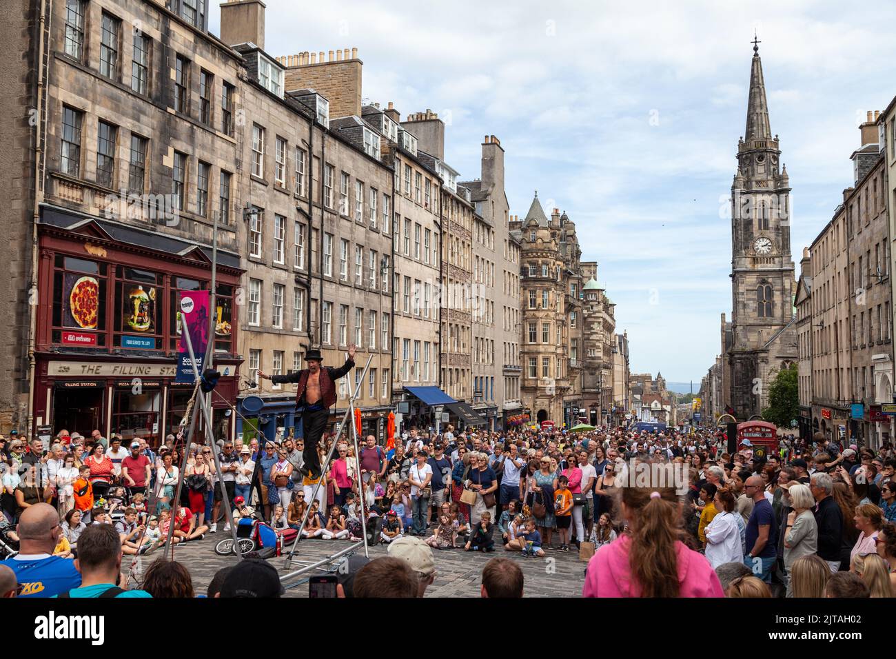 Un bus du Festival d'Édimbourg sur le Royal Mile effectuant des randonnées en corde raide Banque D'Images