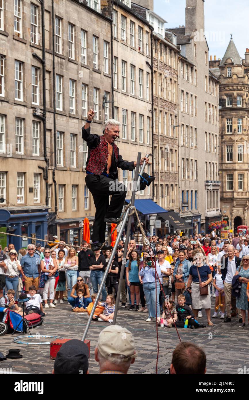 Un bus du Festival d'Édimbourg sur le Royal Mile effectuant des randonnées en corde raide Banque D'Images