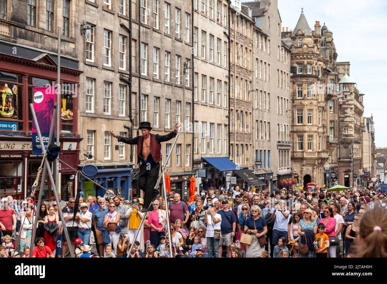 Un bus du Festival d'Édimbourg sur le Royal Mile effectuant des randonnées en corde raide Banque D'Images