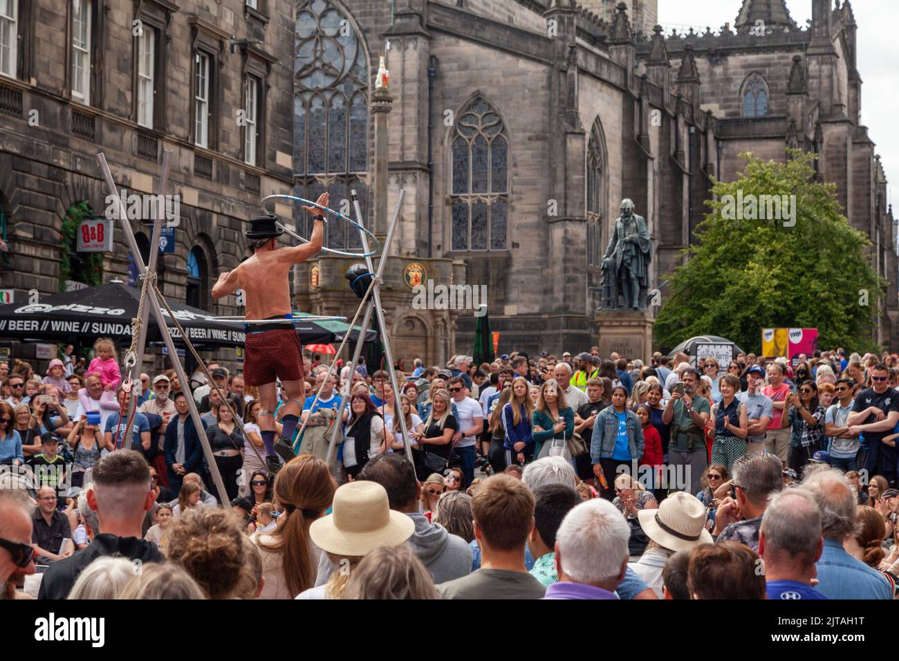 Un bus du Festival d'Édimbourg sur le Royal Mile effectuant des randonnées en corde raide Banque D'Images