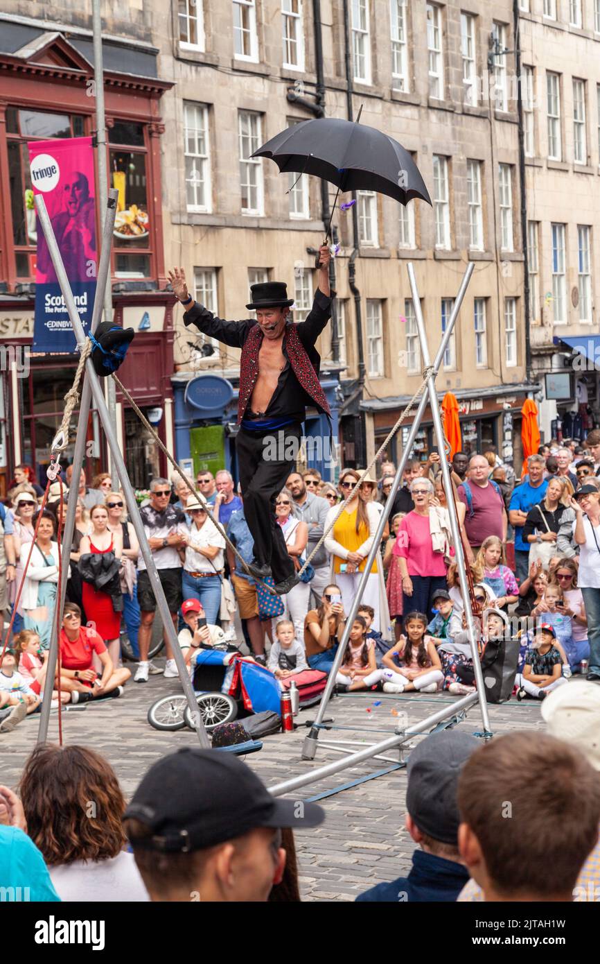 Un bus du Festival d'Édimbourg sur le Royal Mile effectuant des randonnées en corde raide Banque D'Images