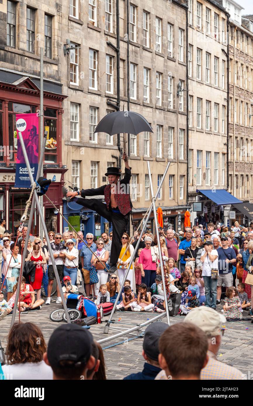 Un bus du Festival d'Édimbourg sur le Royal Mile effectuant des randonnées en corde raide Banque D'Images