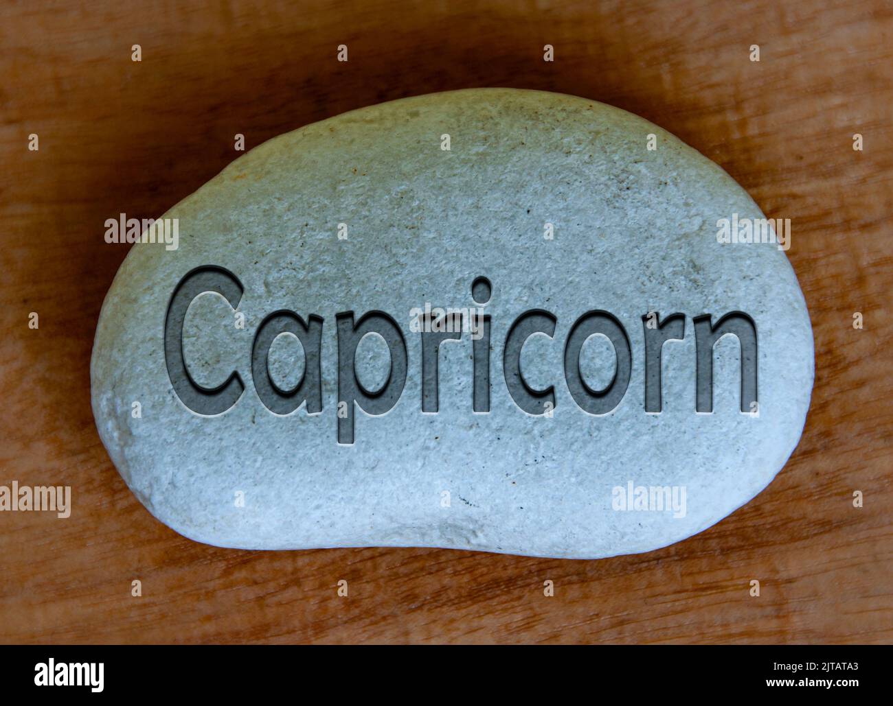 Capricorne zodiaque texte de signe gravé sur un stock avec fond en bois. Concept de signe de zodiaque. Banque D'Images