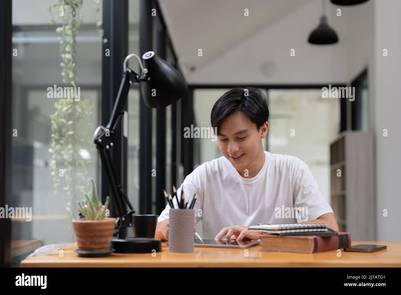 Jeunes étudiants asiatiques qui utilisent une tablette numérique pour étudier à distance, regarder un webinaire en ligne, effectuer un zoom sur la formation virtuelle lors d'une réunion par vidéoconférence. Banque D'Images