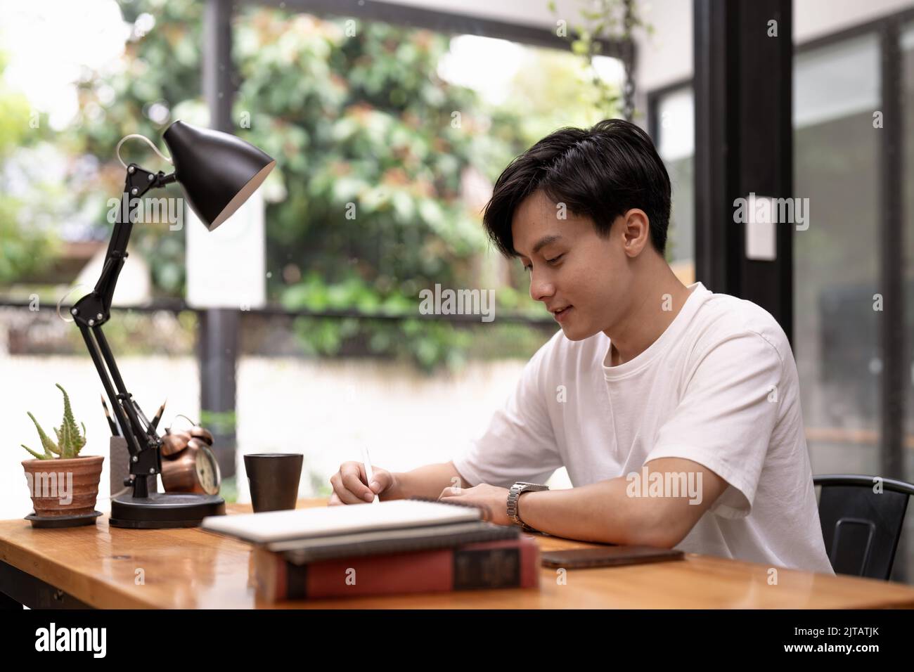 Jeunes étudiants asiatiques qui utilisent une tablette numérique pour étudier à distance, regarder un webinaire en ligne, effectuer un zoom sur la formation virtuelle lors d'une réunion par vidéoconférence. Banque D'Images