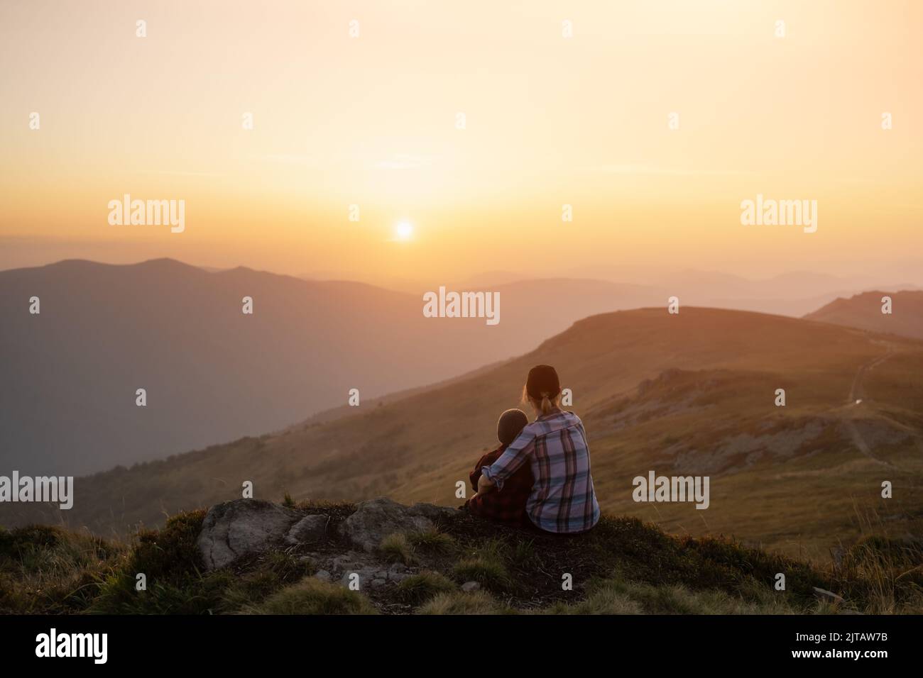 Maman avec son fils dans les montagnes d'automne au coucher du soleil. Concept Voyage avec enfant Banque D'Images