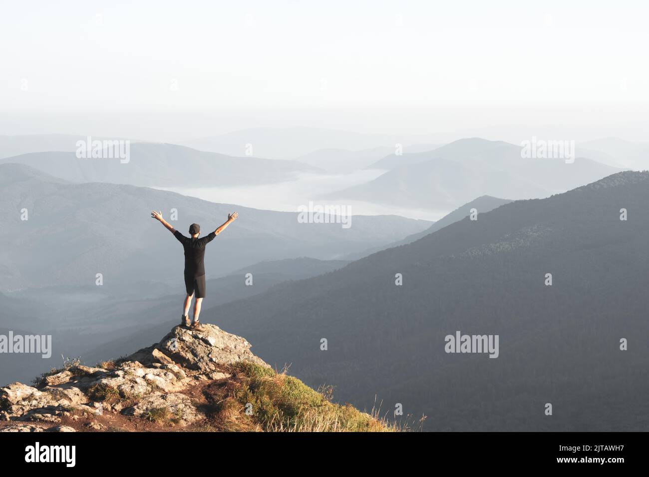 Seul touriste sur le bord de la falaise avec la toile de fond d'un incroyable paysage de montagnes au lever du soleil. Concept de voyage Banque D'Images