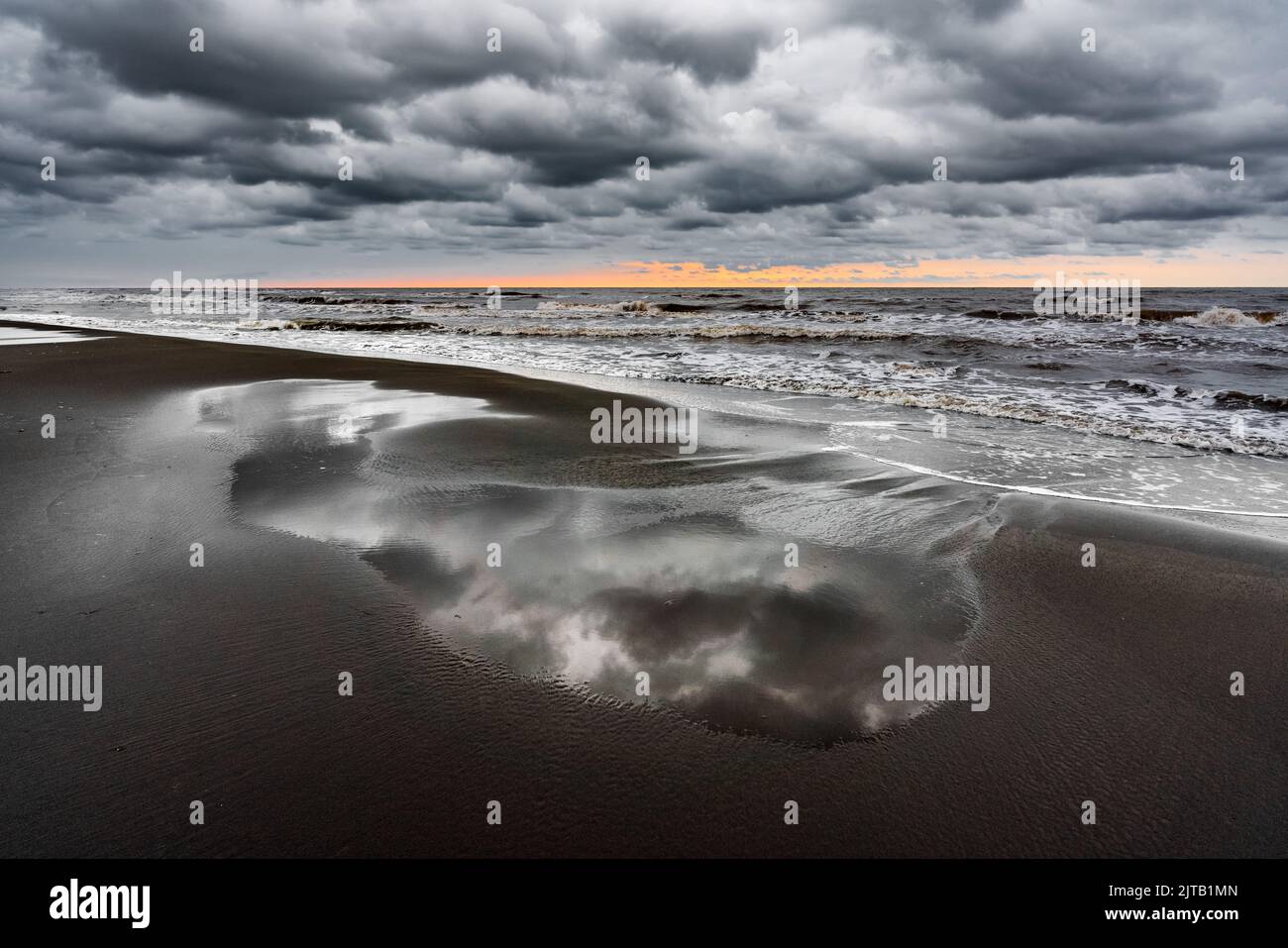 Vagues sur la plage de la mer par un jour pluvieux nuageux Banque D'Images