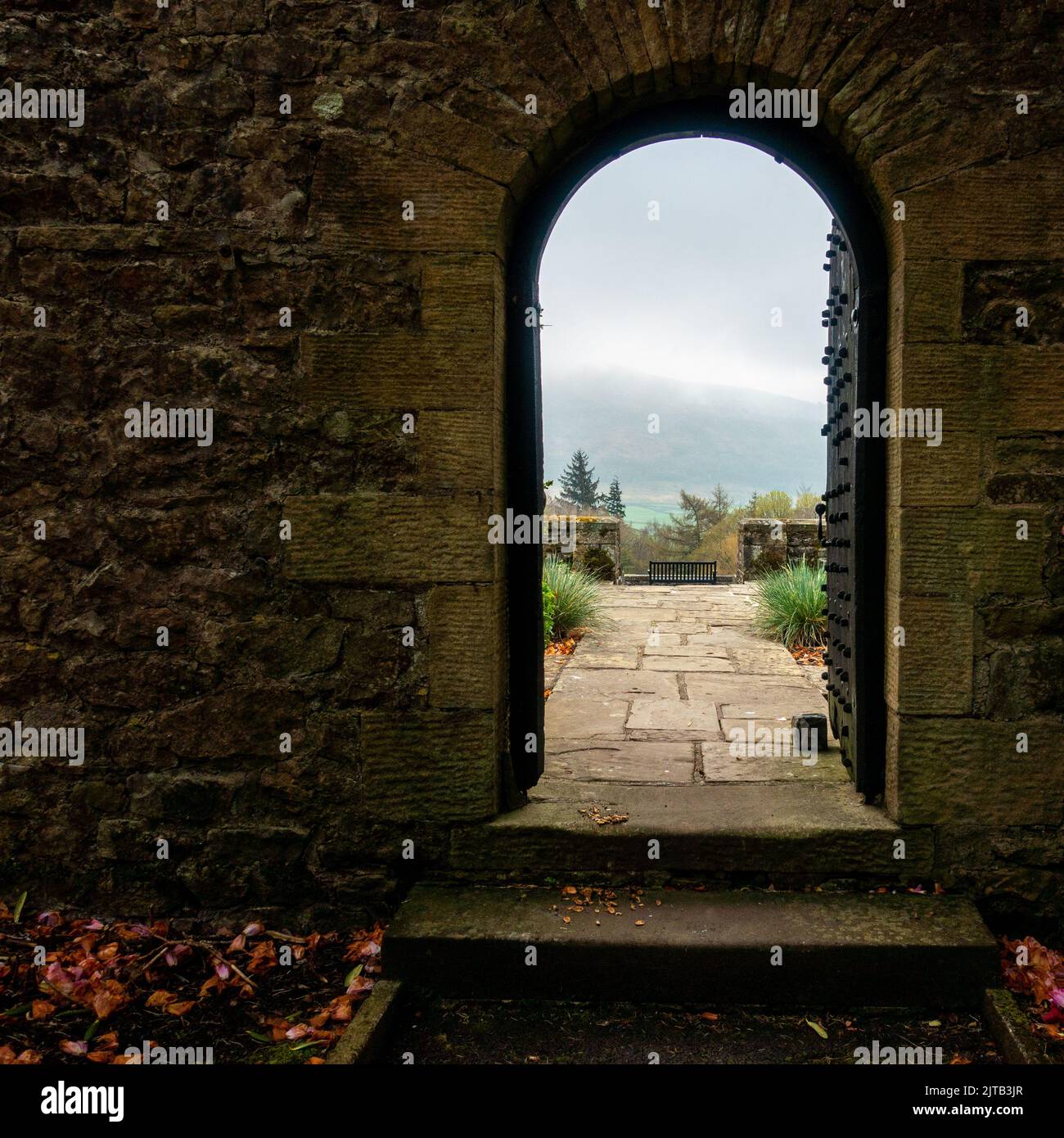Vue sur les jardins et les landes brumeuses à travers une arcade au Parcevall Hall au printemps, dans le parc national de Yorkshire Dales, Royaume-Uni Banque D'Images