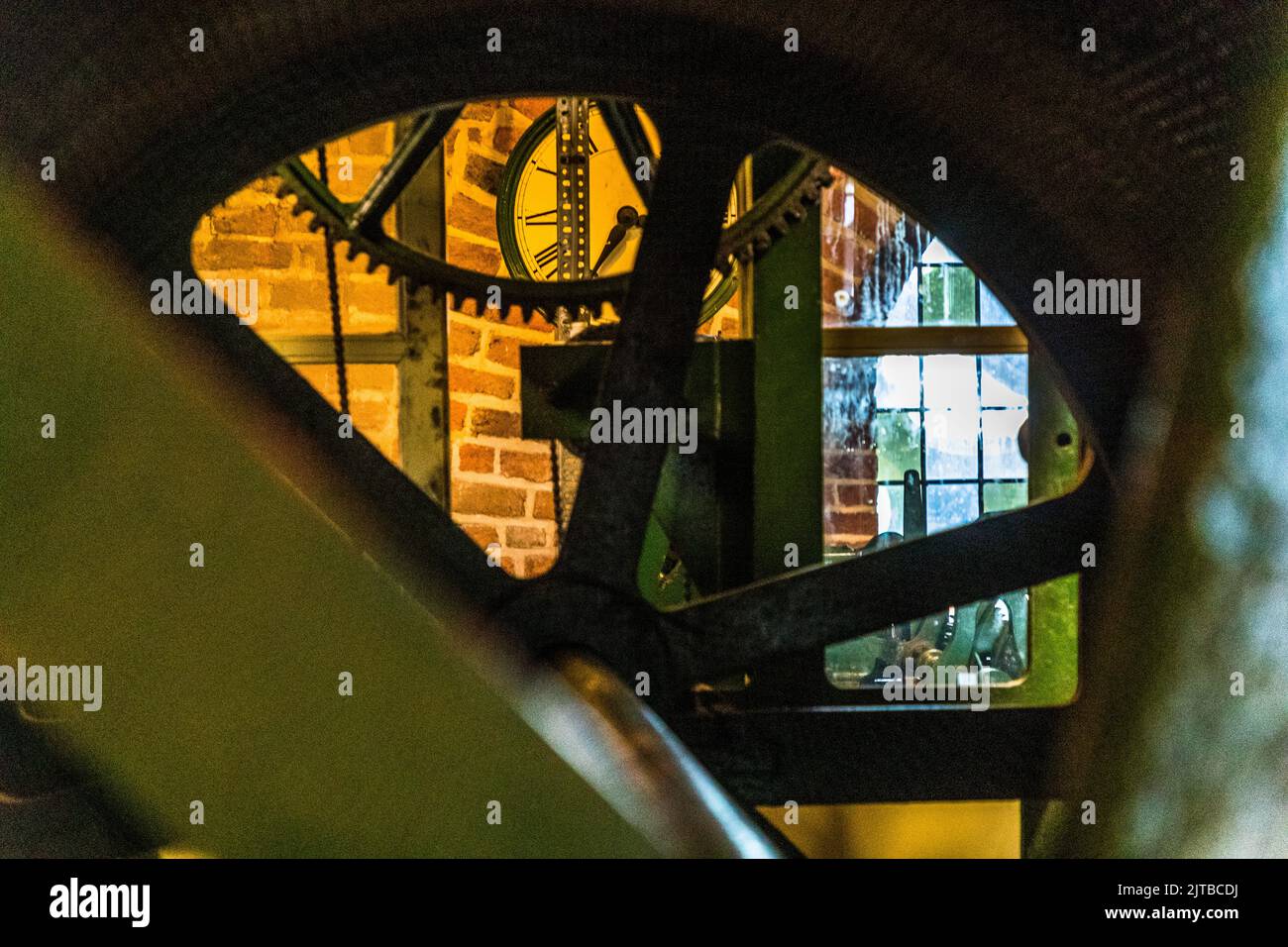 L’horlogerie de l’église Saint-Lebuïnus à Deventer, l’une des neuf villes hanséatiques historiques sur la rivière IJssel, province d’Overijssel, Pays-Bas, a été fabriquée en 1862 par l’horloger parisien Amédée-Philippe Borrel ; le tambour de jeu pour le carillon a été livré en 1866 par la fonderie de fer de Deventer Nering Bögel. Encadrée par un grand engrenage du mécanisme, l’horloge de la tour est visible en arrière-plan, avec une étroite ouverture de fenêtre donnant sur le mur en brique de la tour devant elle. Banque D'Images