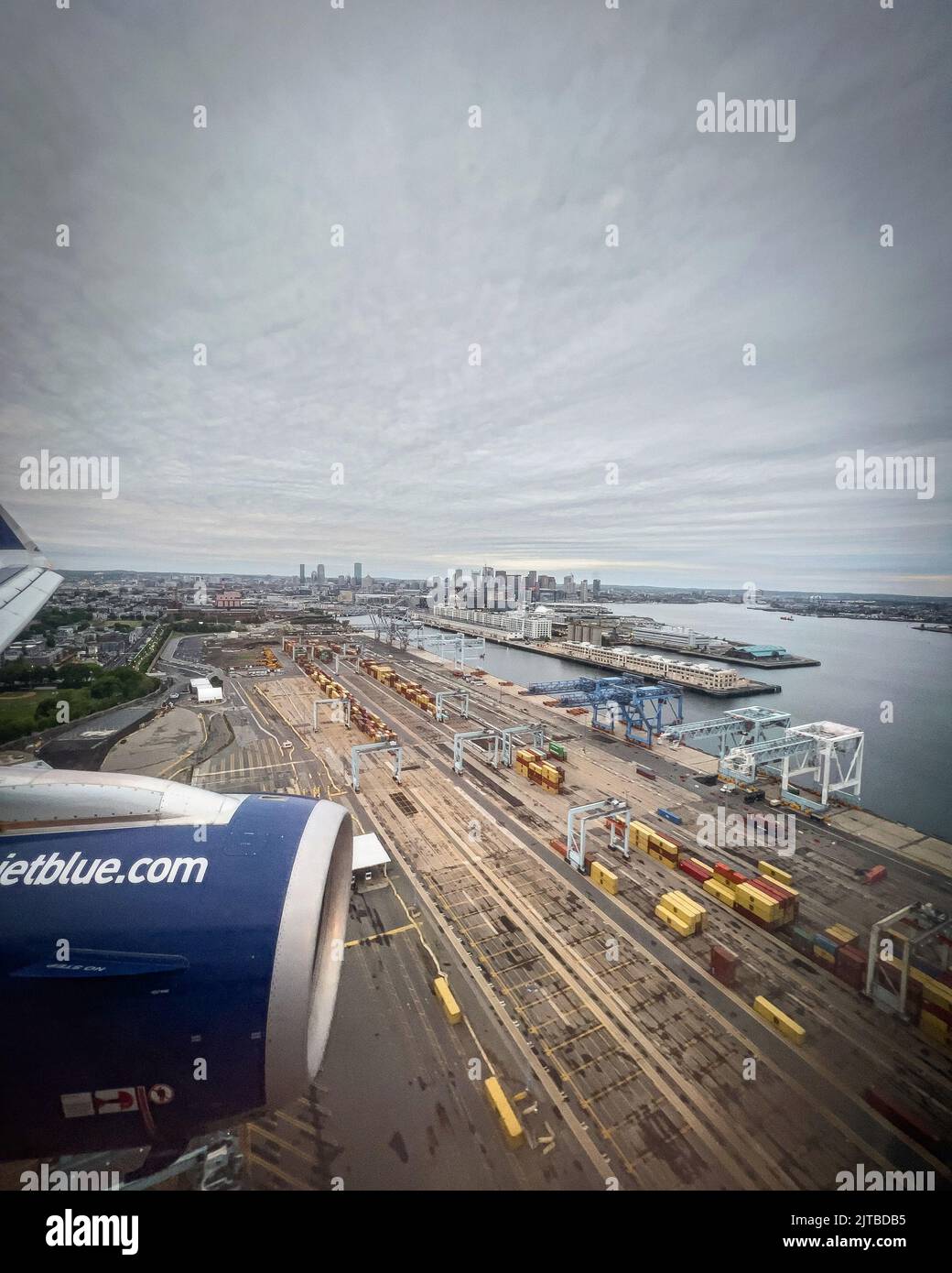 Un avion bleu-jet se préparant à atterrir à Boston États-Unis par une journée ensoleillée et nuageux Banque D'Images Un avion bleu-jet se préparant à atterrir à Boston États-Unis par une journée ensoleillée et nuageux Banque D'Images