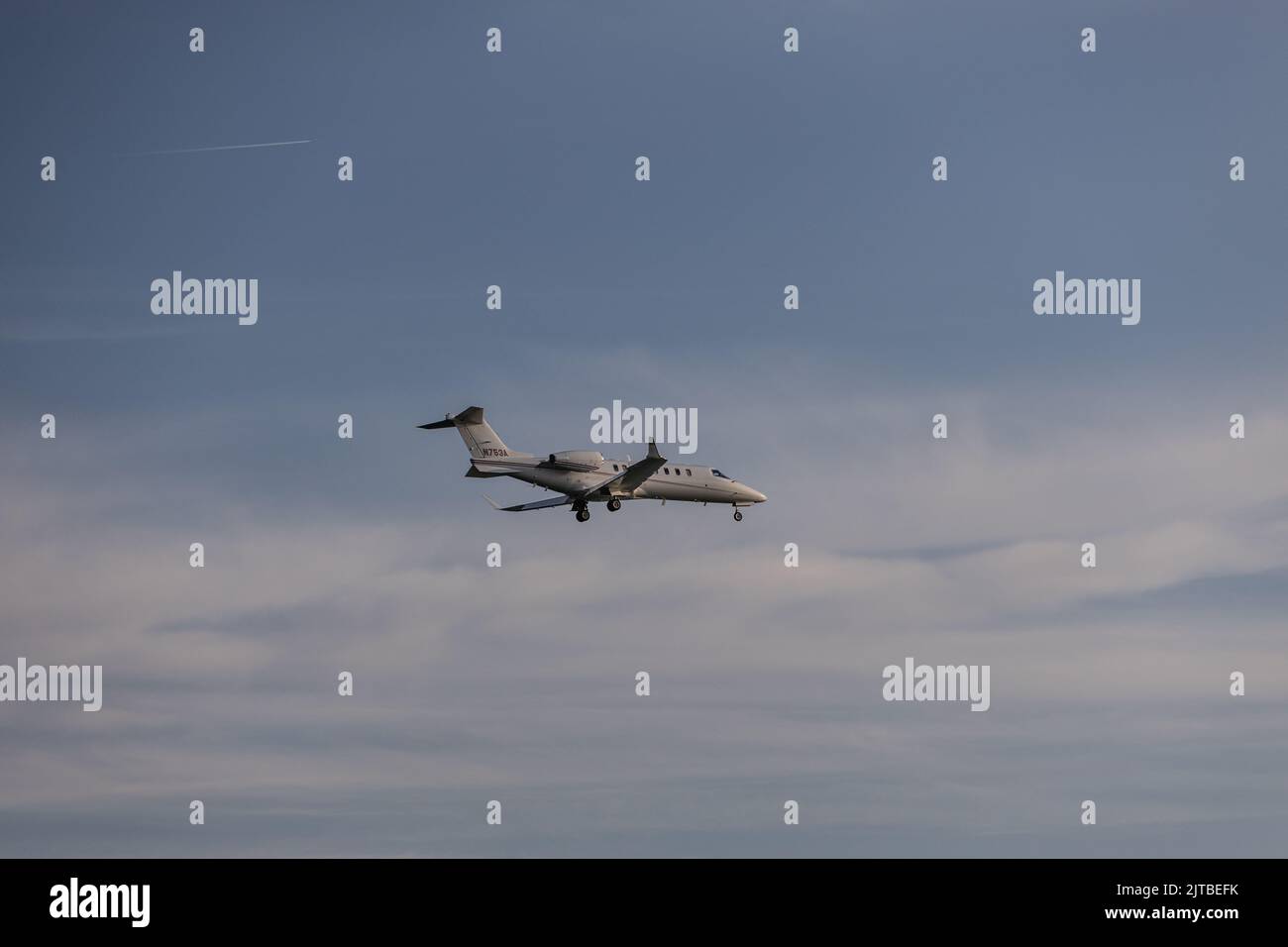 Un jet privé volant dans le ciel bleu avant l'atterrissage Banque D'Images