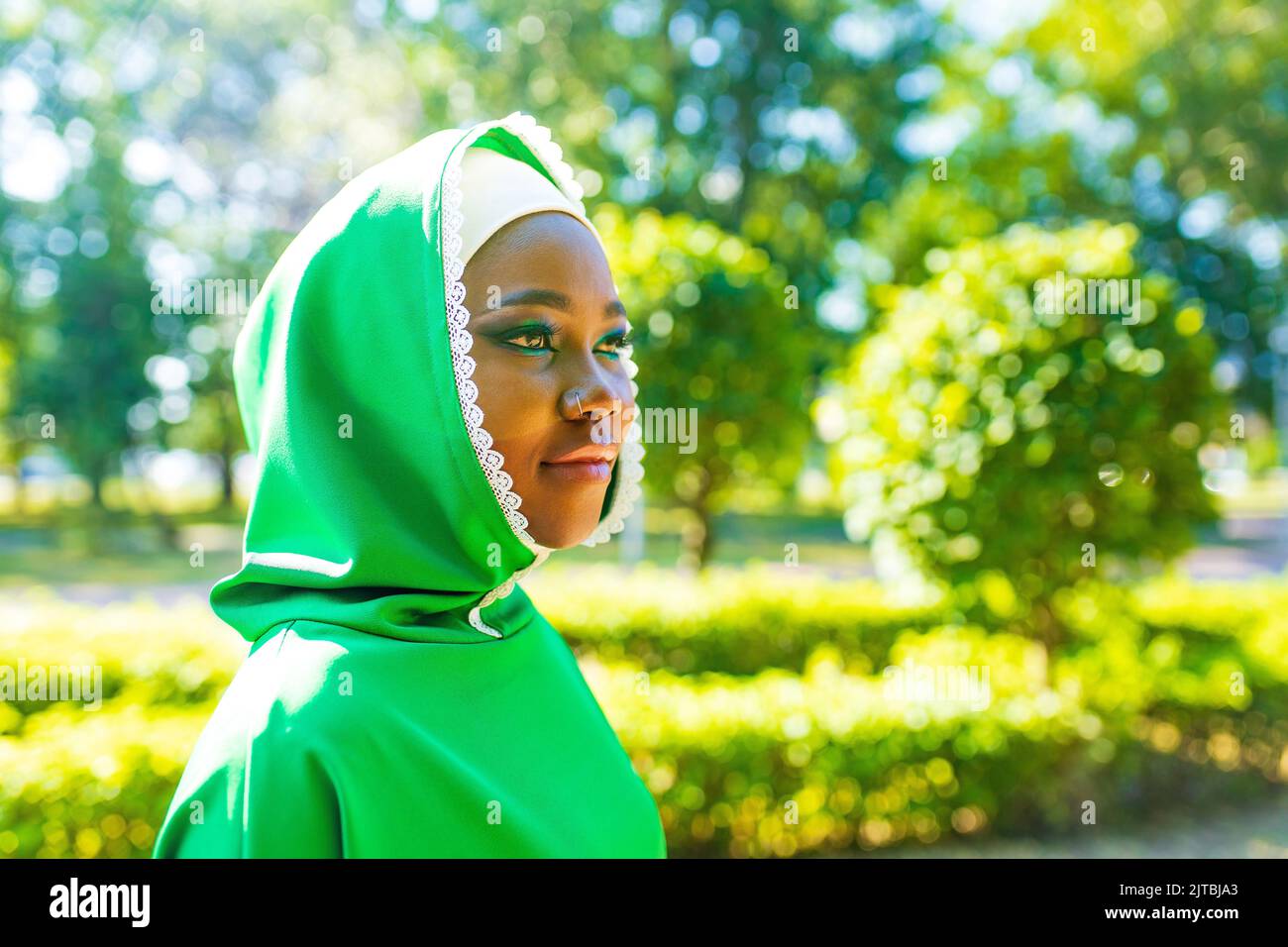 moderne authentique race multiculturelle femme islamique en coton vert hijab avec magnifique maquillage en plein air dans le parc d'été Banque D'Images
