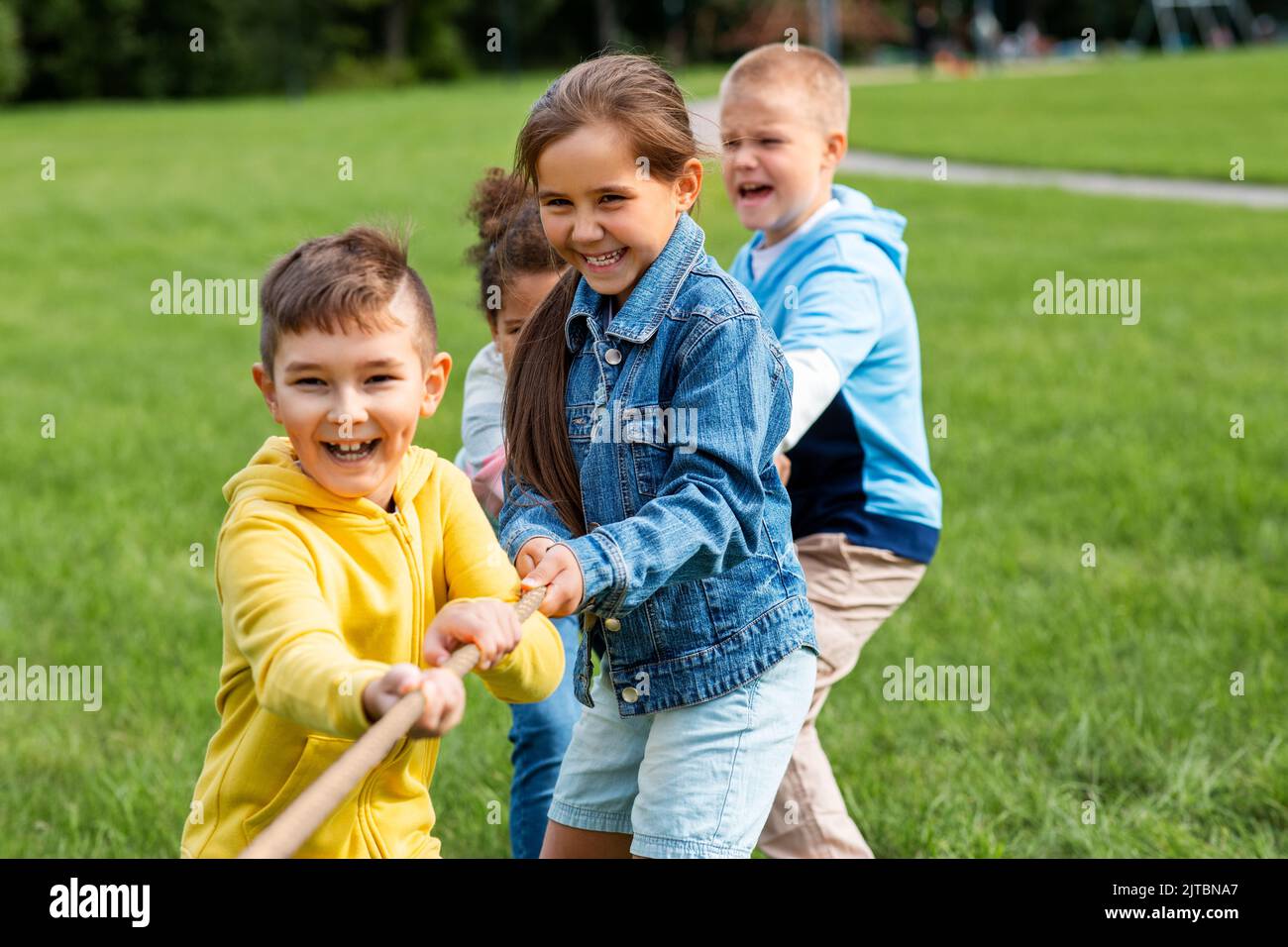 des enfants heureux jouant au jeu de remorqueurs de guerre au parc Banque D'Images