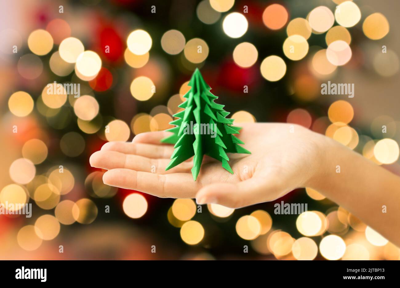 main tenant l'arbre de noël en papier vert origami Banque D'Images