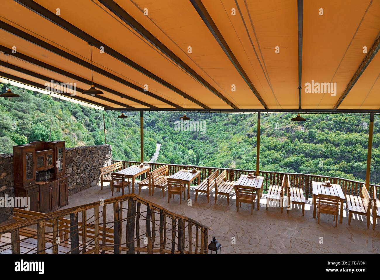 Tables et chaises en bois fabriquées dans un restaurant en plein air prêt à accueillir les clients, avec toit en toile lumineuse Banque D'Images