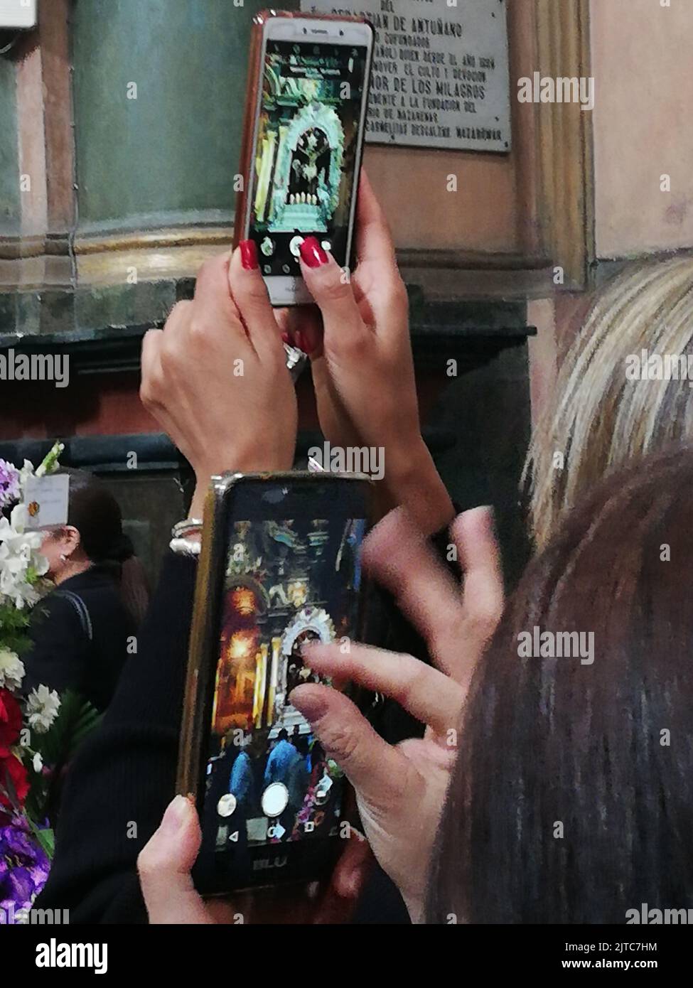 Les dévotés prenant des photos de l'autel principal et de l'image processionnelle avec leurs téléphones mobiles à l'église Las Nazarenas - Seigneur des miracles. Banque D'Images