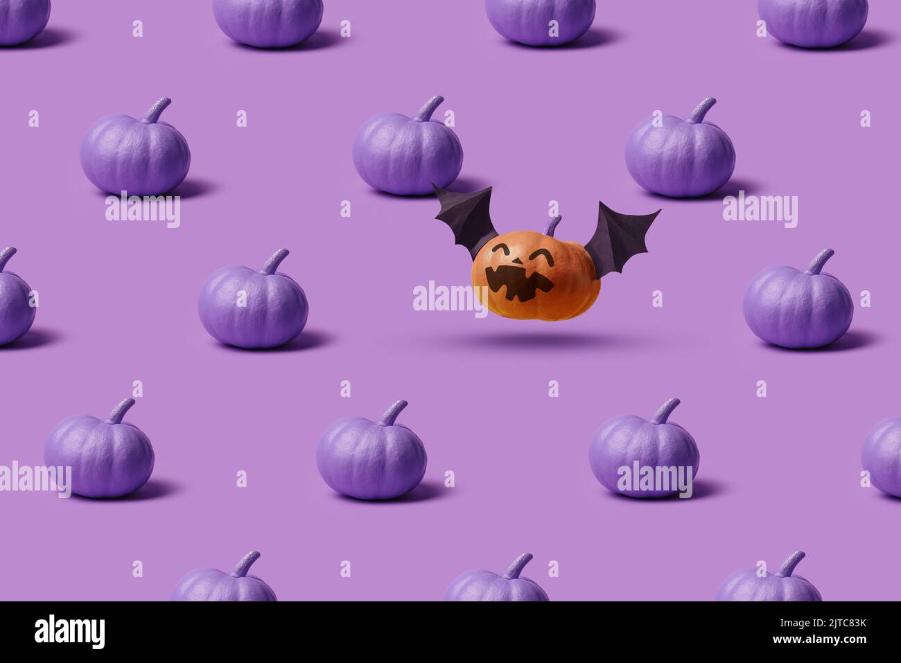 Motif, citrouilles d'Halloween, sans visage et avec un visage mal et des ailes de chauve-souris. Décor minimaliste de Noël violet Banque D'Images