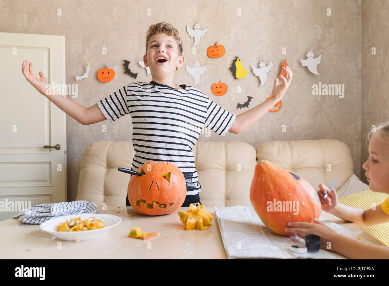 Un garçon coupe une citrouille pour Halloween et Amuse-toi bien. Banque D'Images