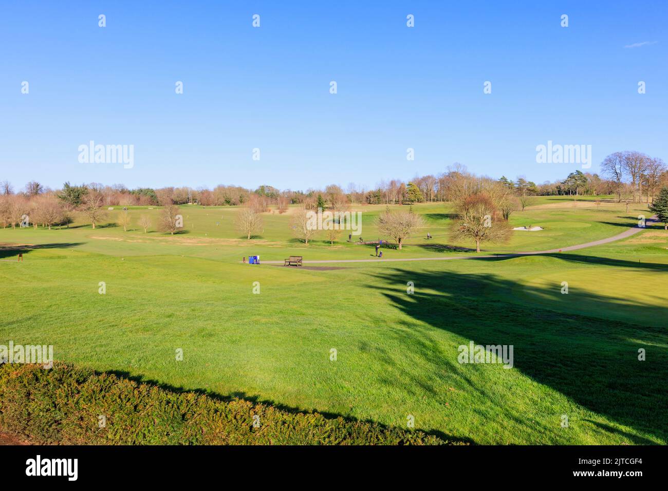 Vue sur les golfeurs qui jouent sur le parcours de golf au club privé des membres du RAC à Woodcote Park, Epsom, Surrey, Angleterre du sud-est par une journée ensoleillée Banque D'Images