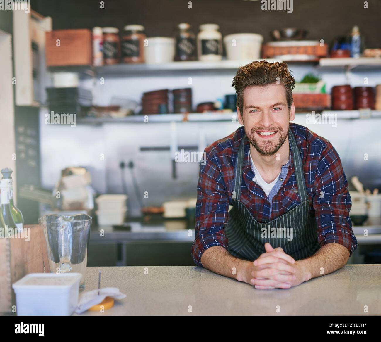 Vous êtes prêt à commander. Portrait d'un jeune barista travaillant derrière le comptoir dans son café. Banque D'Images