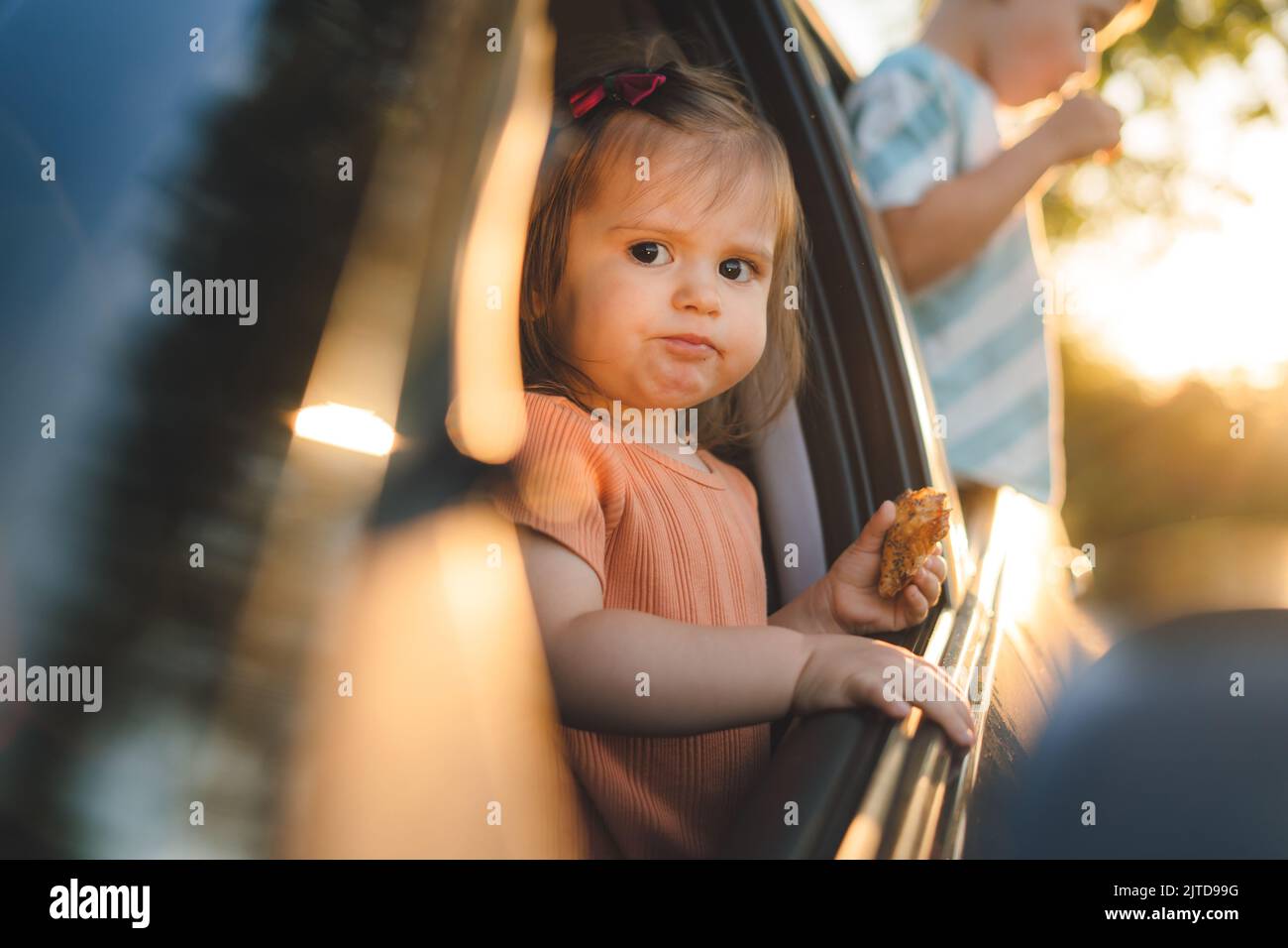 Deux enfants qui collent la tête hors des fenêtres d'une voiture en regardant vers l'avant pour un voyage ou un voyage en voiture. Concept de voyage sur route. Vacances d'été. Banque D'Images